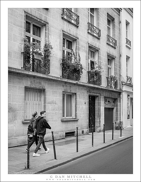 Two pedestrians, Sidewalk and Buildings