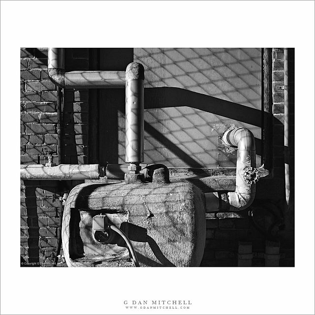 Pipes, Tank, and Cyclone Fence Shadows